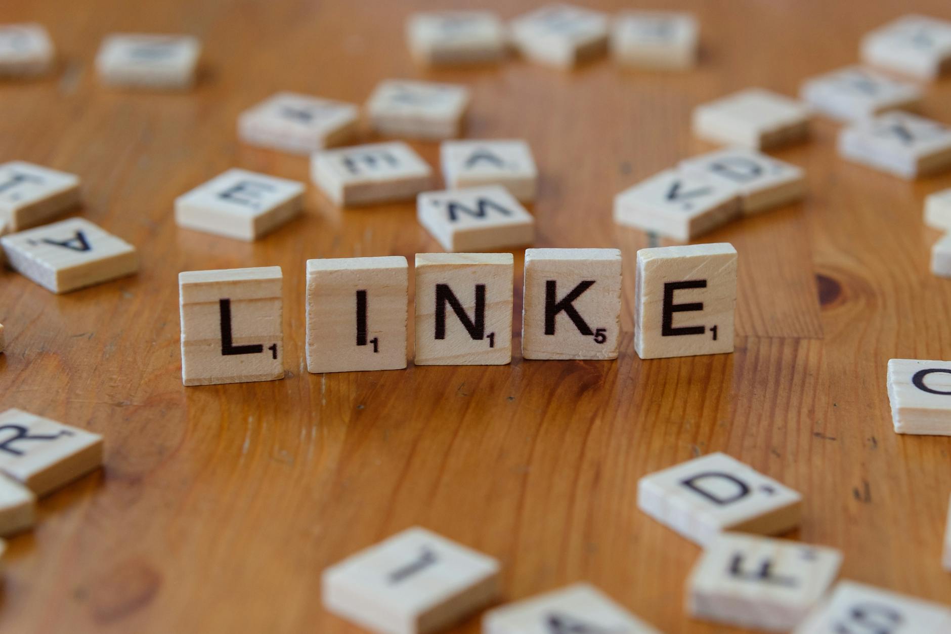 wooden scrabble letters spelling linke on table